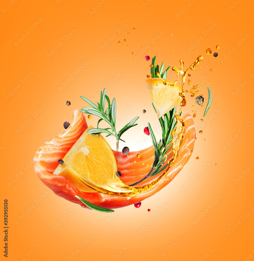 Slice of fresh salmon with flavored spices and lemon in the air on a yellow background