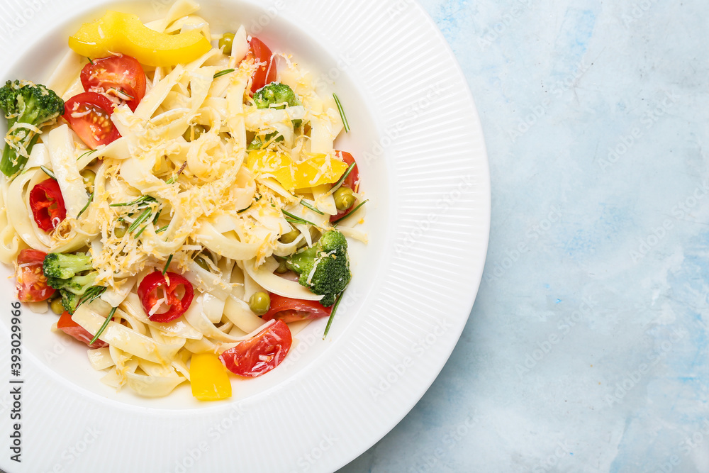 Plate with tasty pasta primavera on color background