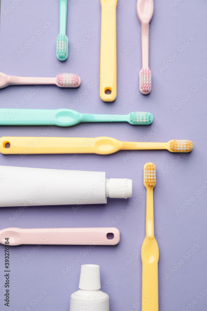 Toothbrushes and paste on color background