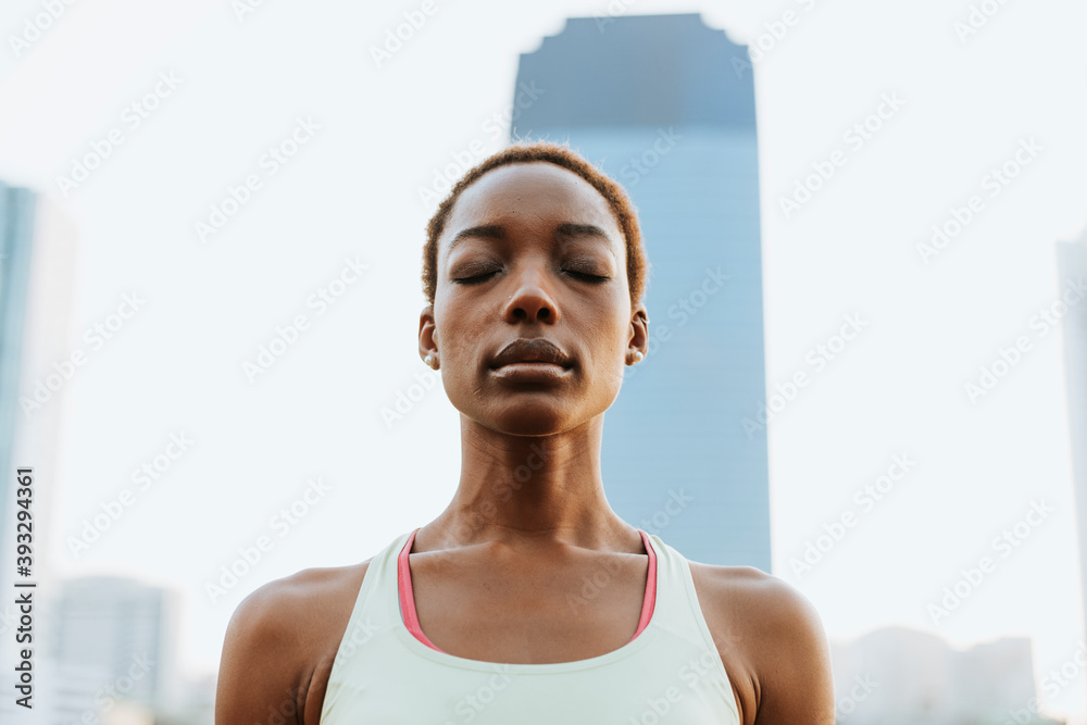 Black lady making a meditation at a park