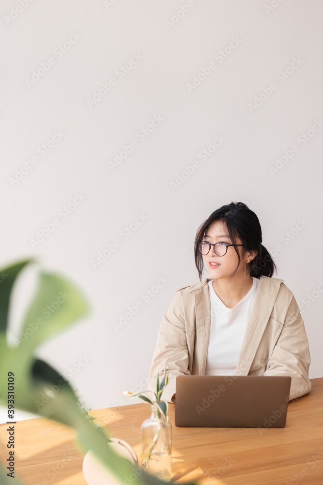 Happy Asian woman working at home using a laptop