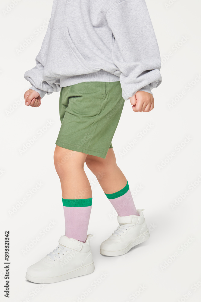 Kid wearing gray sweatshirt white sneakers studio shot