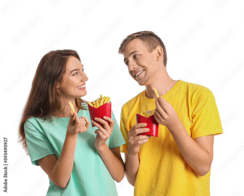 Young couple with french fries on white background