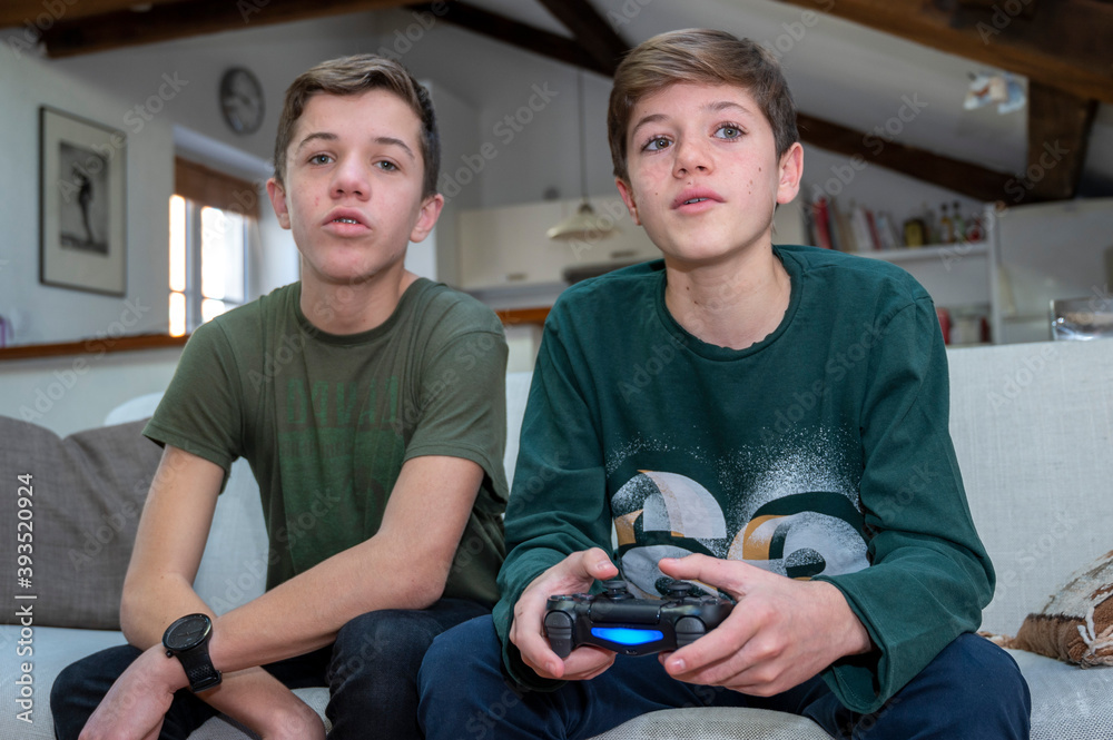 Adolescents jouant à la console de jeux à la maison