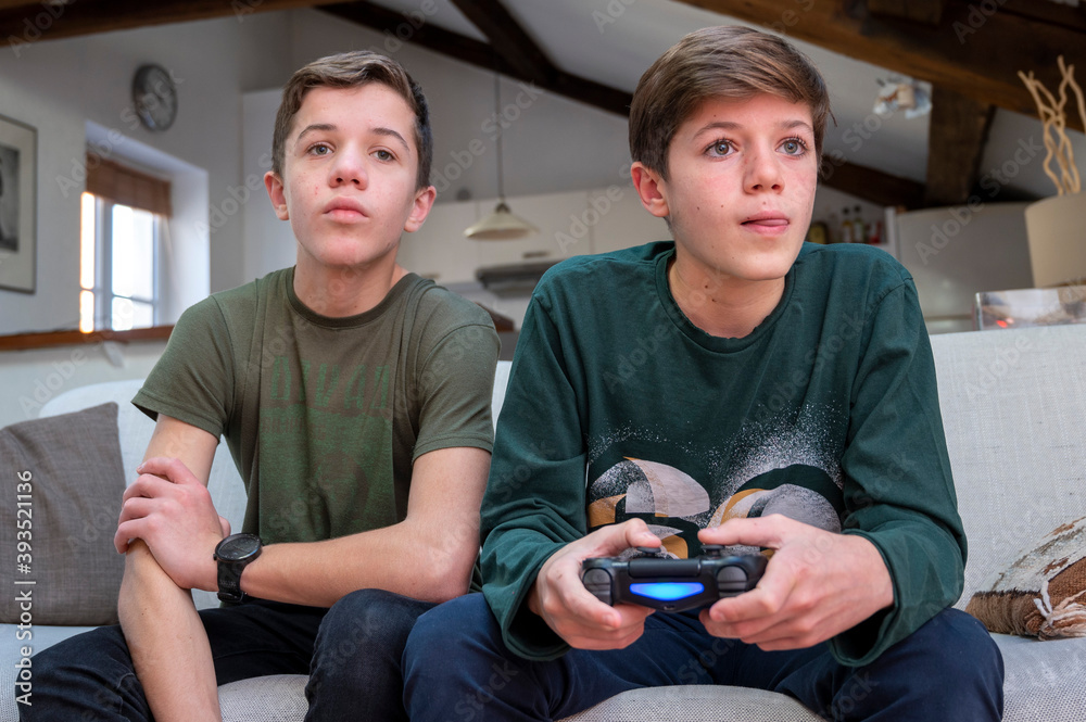 Adolescents jouant à la console de jeux à la maison