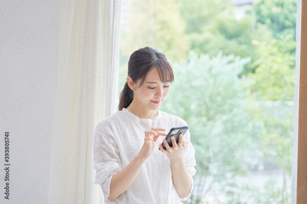 リビングでスマホを使う女性