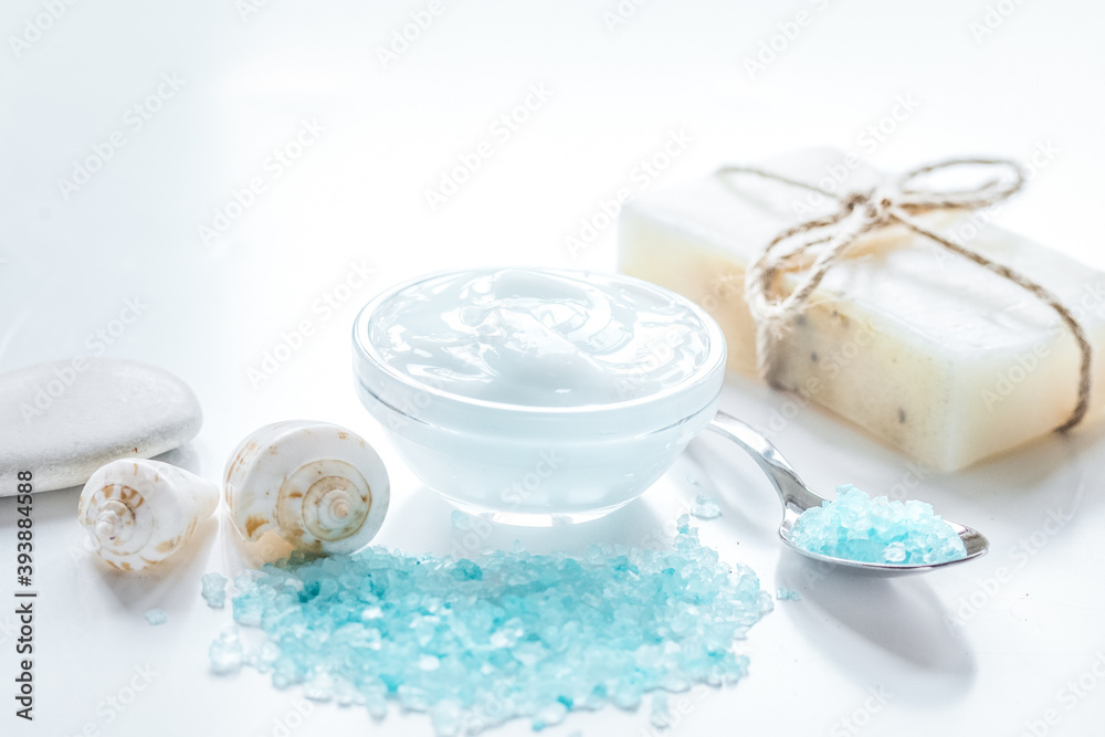 spa composition with blue sea salt and natural soap on white desk background