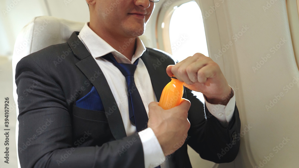 Businessman have orange juice served by an air hostess in airplane . Business trip travel concept .