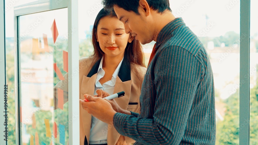 Business people work on project planning board in office and having conversation with coworker frien