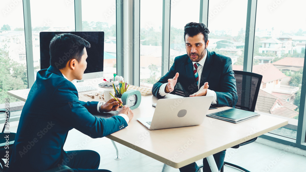 Two business people talk project strategy at office meeting room. Businessman discuss project planni