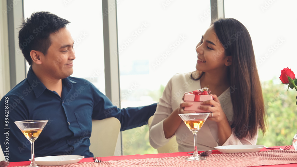 浪漫的情侣在餐厅给爱人送礼物。幸福的情侣生活方式。