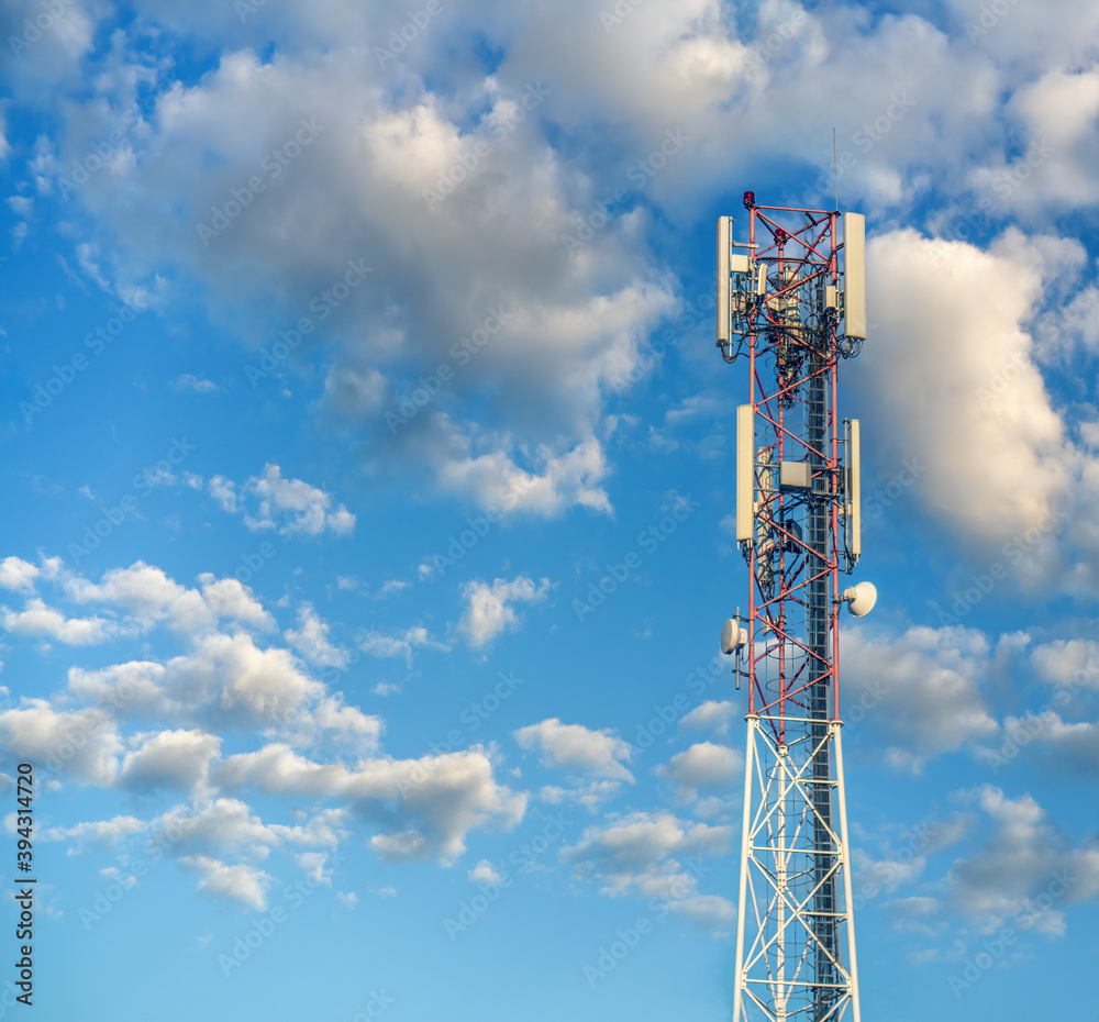 Communication tower with antennas on cloudy sky