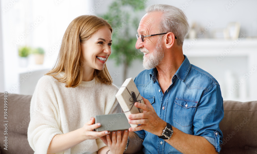 Happy father and daughter examining gift.