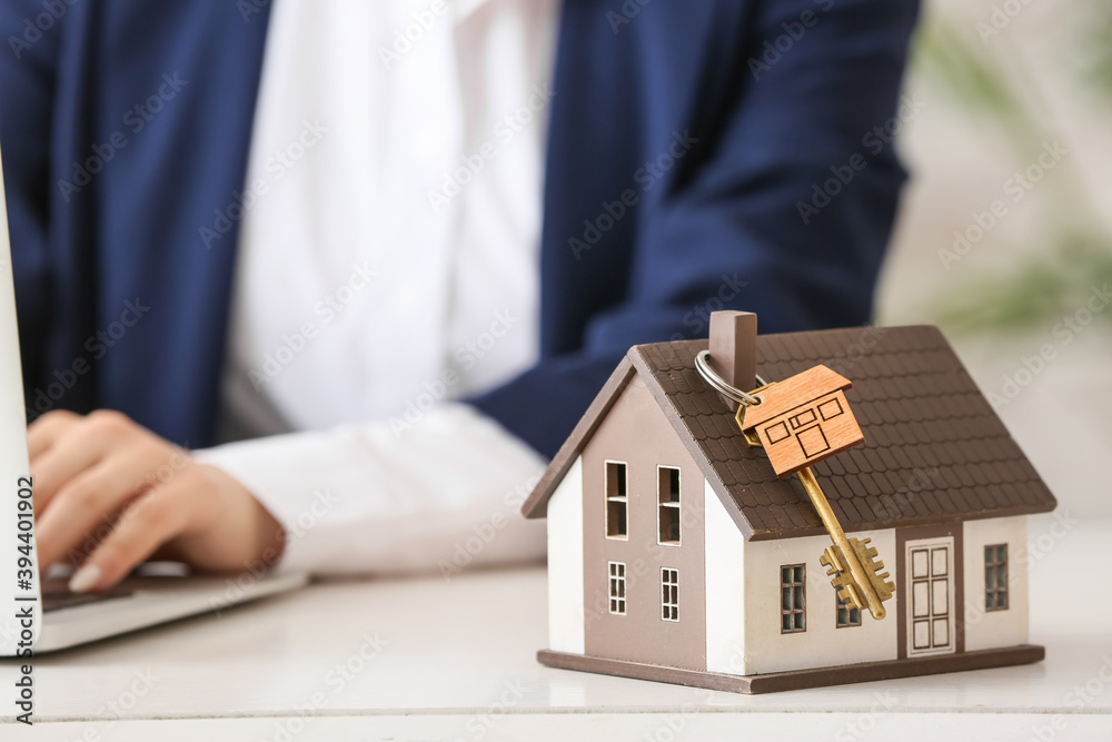 Key from new house on table of real estate agent in office