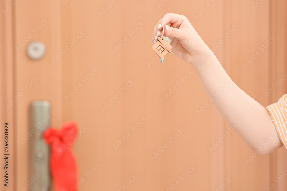 Woman with keys from her new house indoors