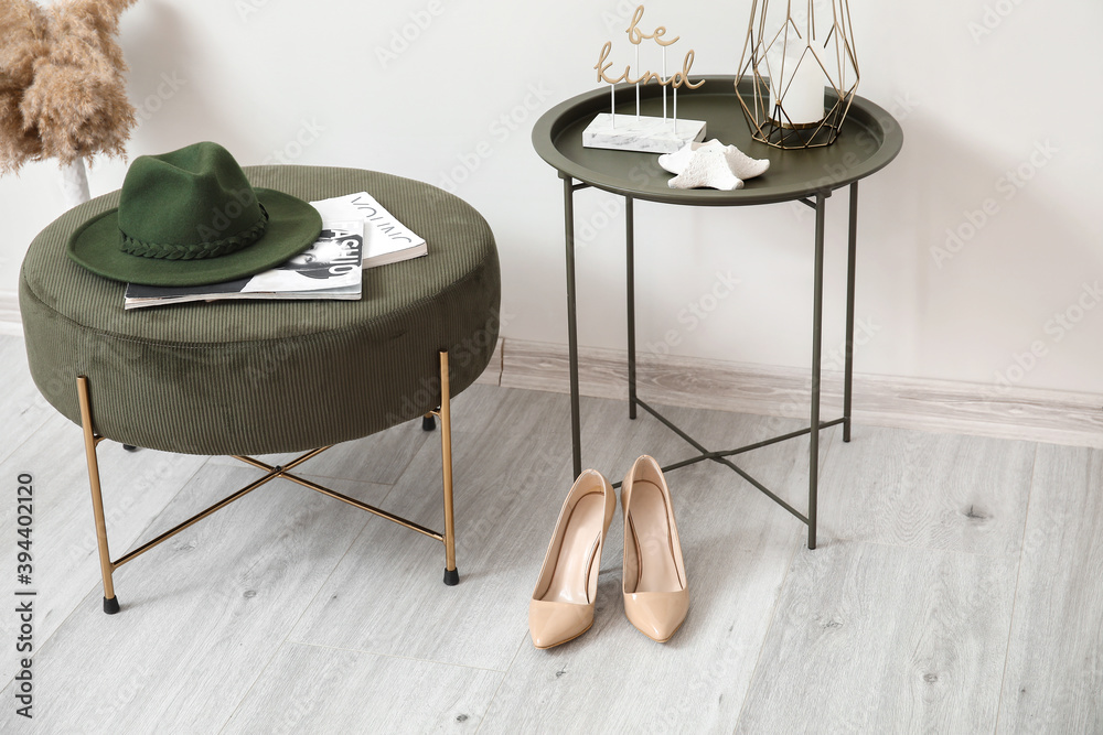 Stylish interior of modern hall with table and pouf