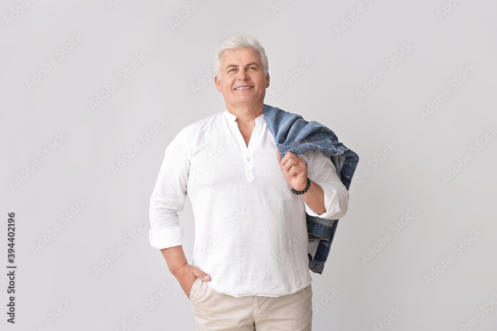 Stylish senior man on grey background