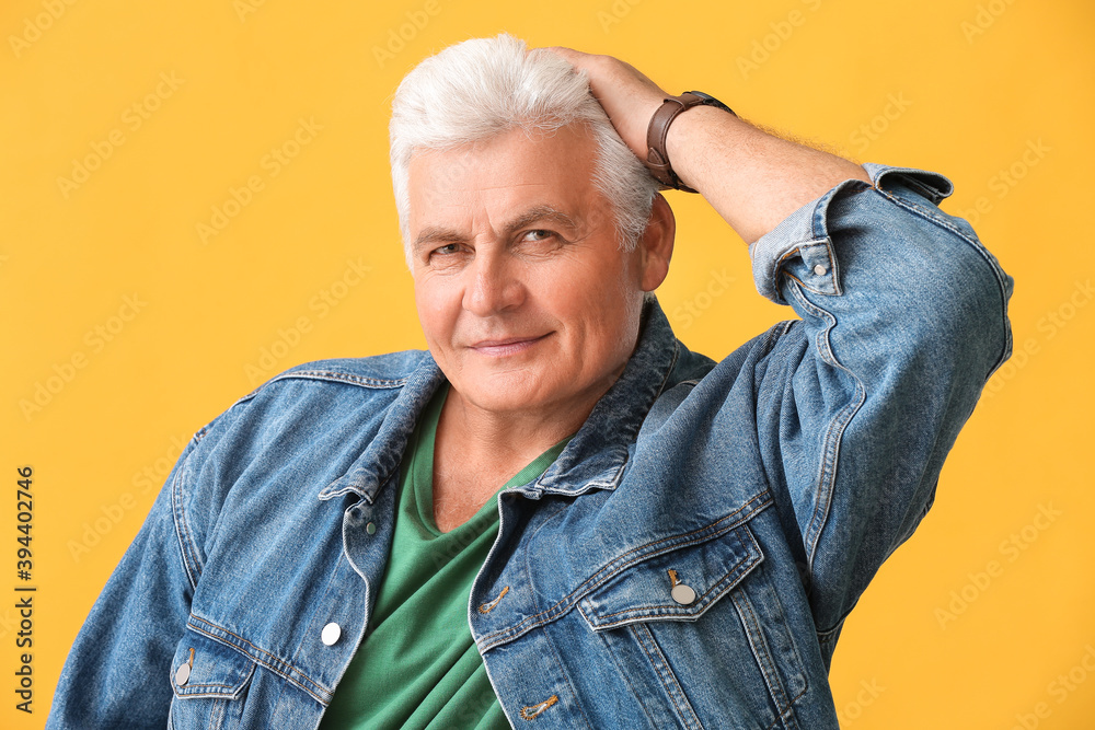 Stylish senior man on color background