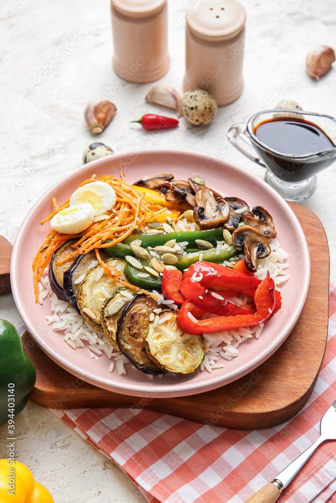 Plate of delicious rice salad with vegetables on light background