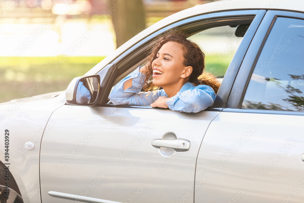 Happy African-American woman looking out of car window