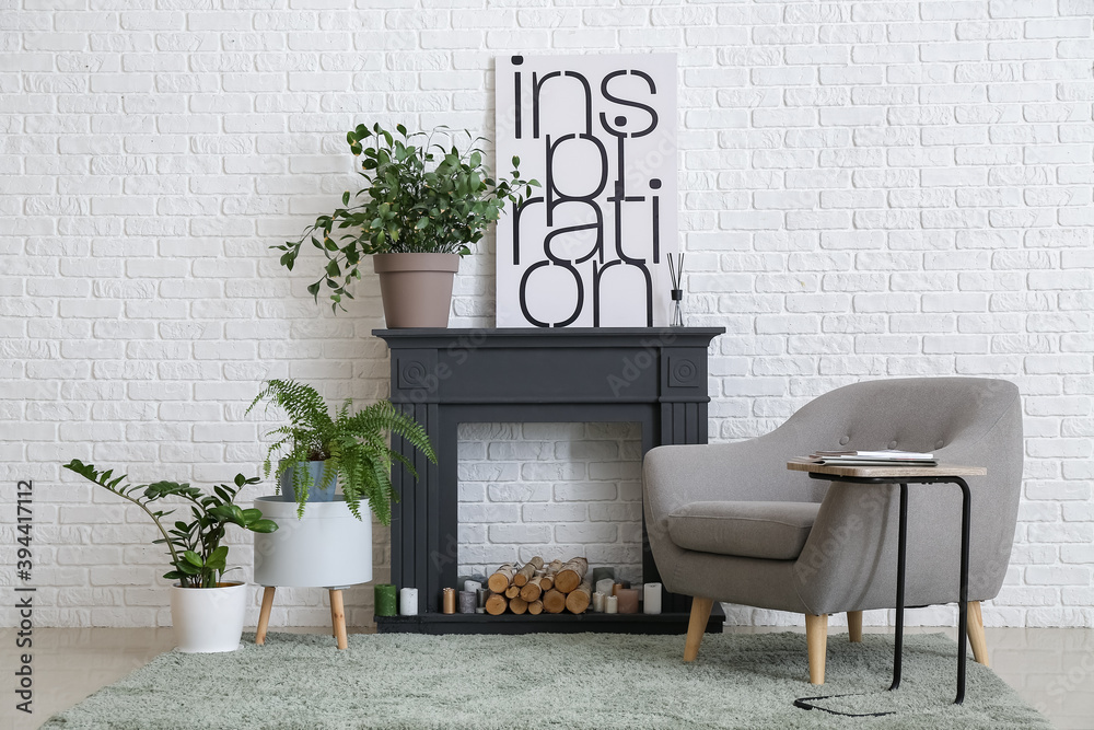 Interior of modern living room with fireplace, houseplants and armchair