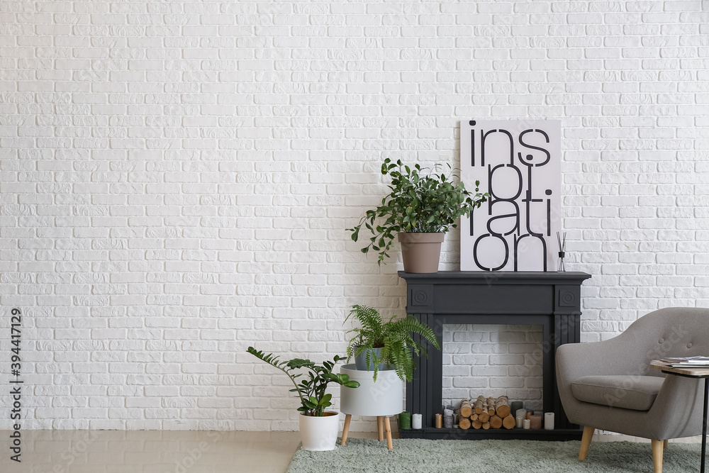 Interior of modern living room with fireplace, houseplants and armchair