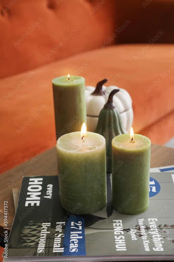 Table with burning candles in interior of living room