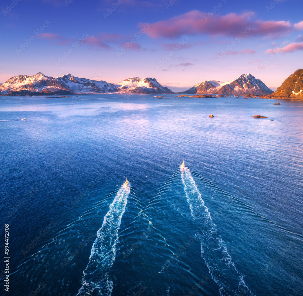 两艘渔船鸟瞰图，碧海中的岩石，雪山和彩云天空