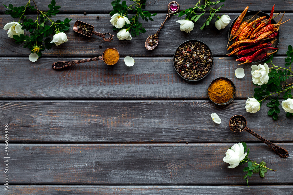 Set of spices and herbs for cooking in metal spoons and bowls, top view