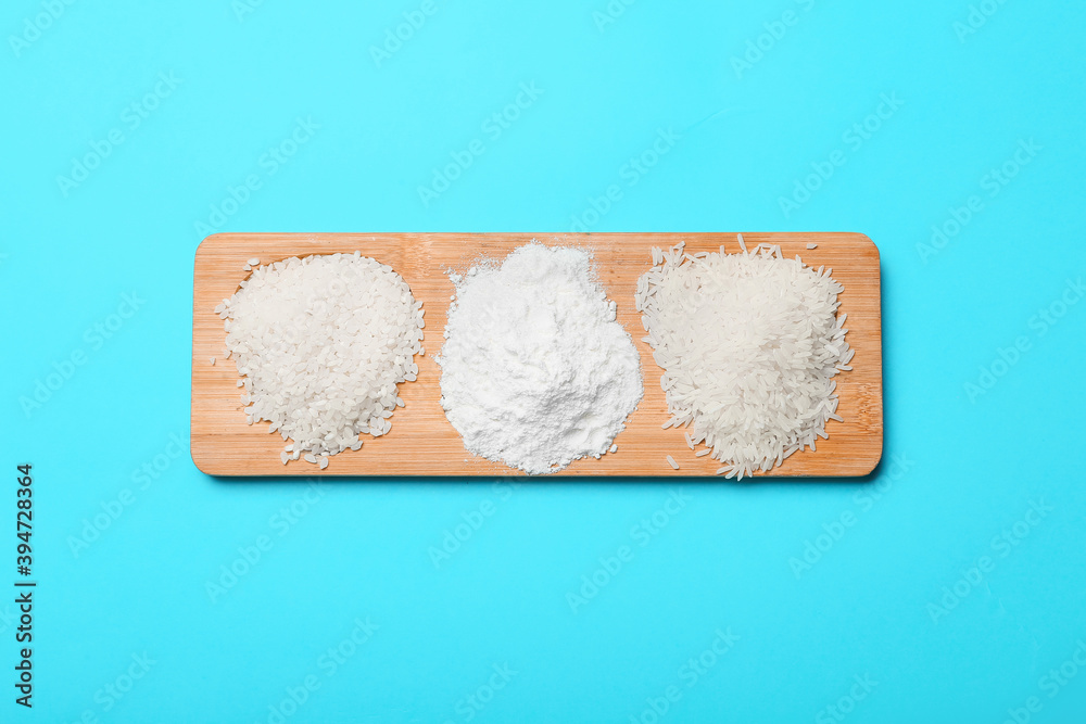 Board with rice and flour on color background