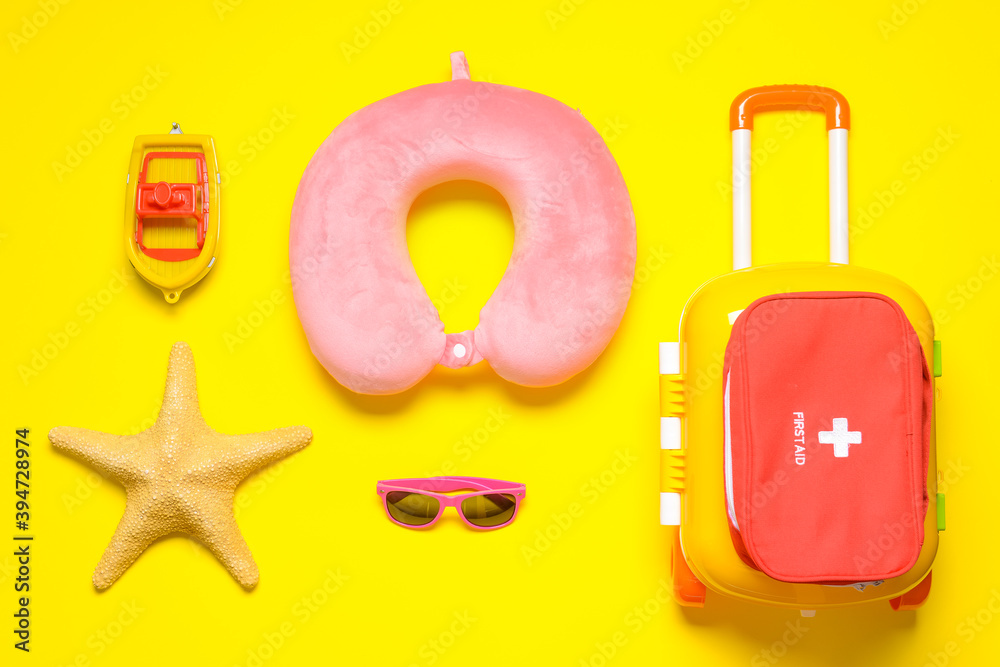 Flat lay composition with child beach accessories and first aid kid on color background. Travel conc