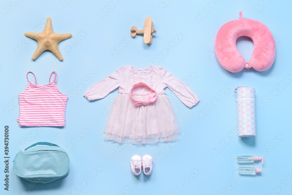 Flat lay composition with little girl accessories on color background. Travel concept