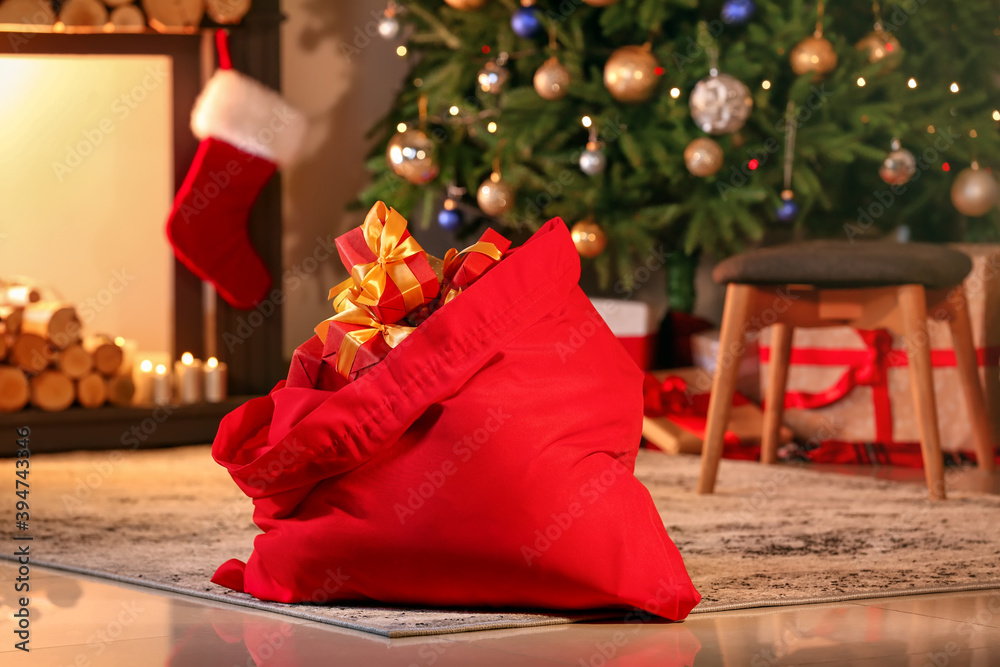 Santa bag with gifts in room decorated for Christmas