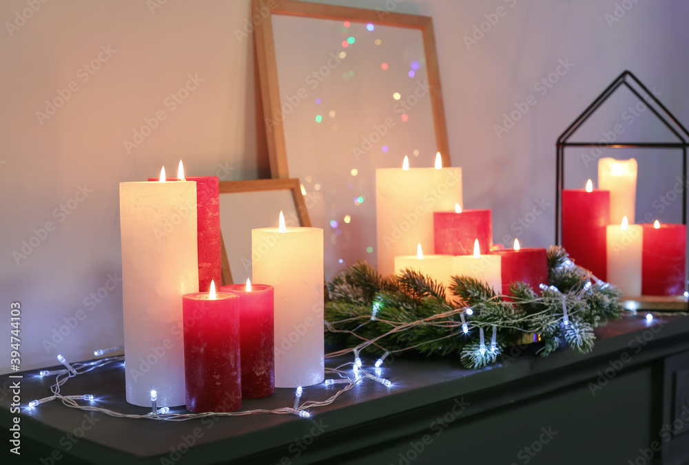 Candles and Christmas decor on mantelpiece in room