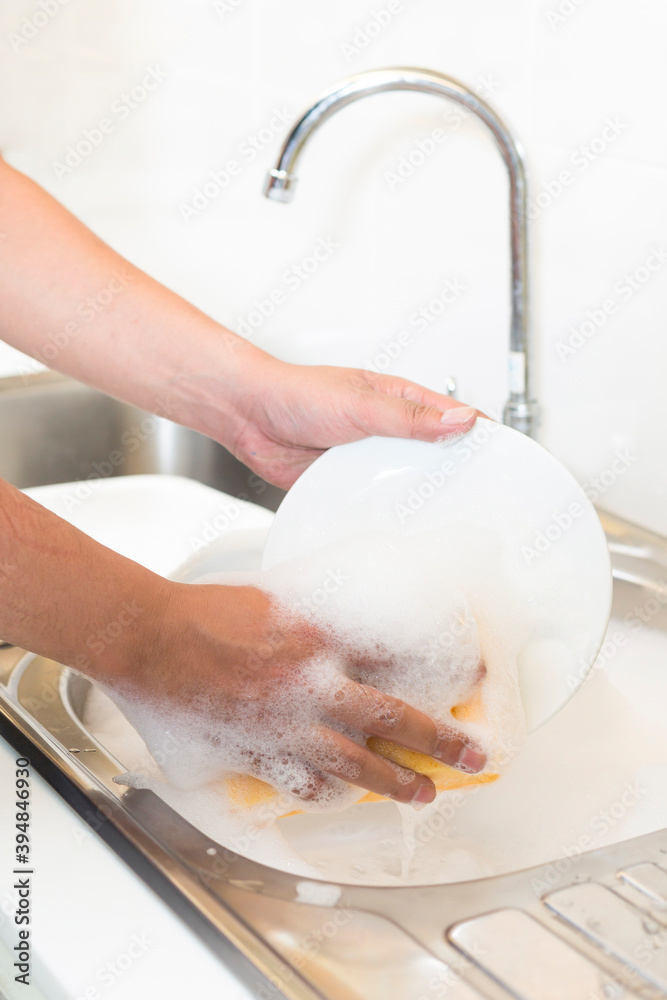 Hand washing dishes with sponge