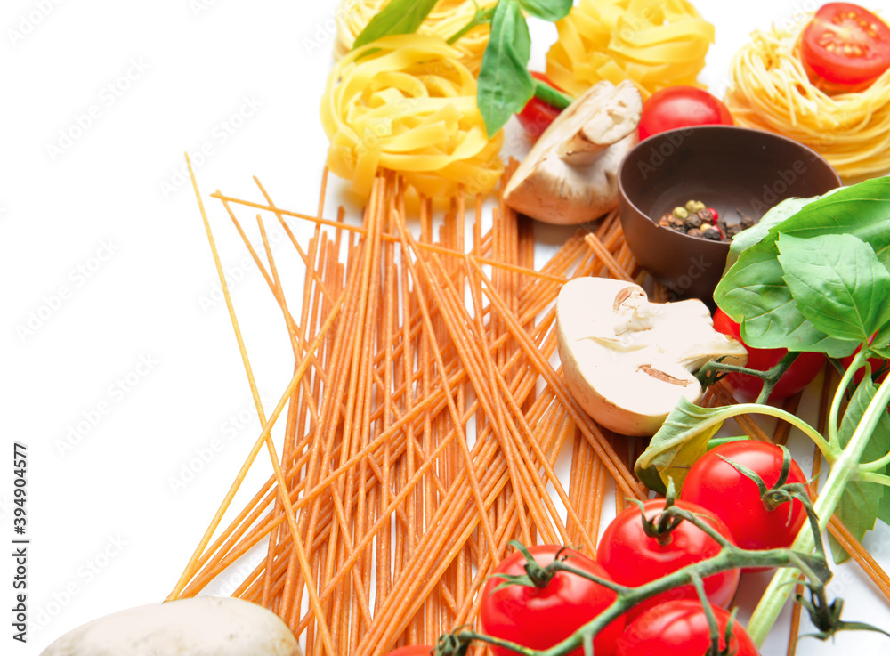 Uncooked pasta and vegetables on white background