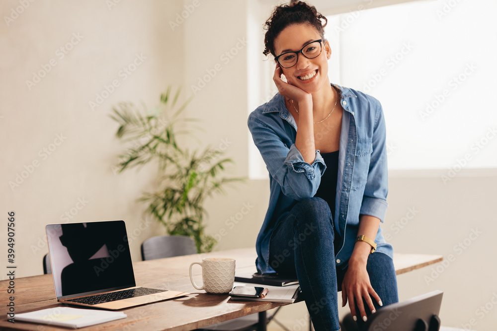 Beautiful woman sitting at table in her home office