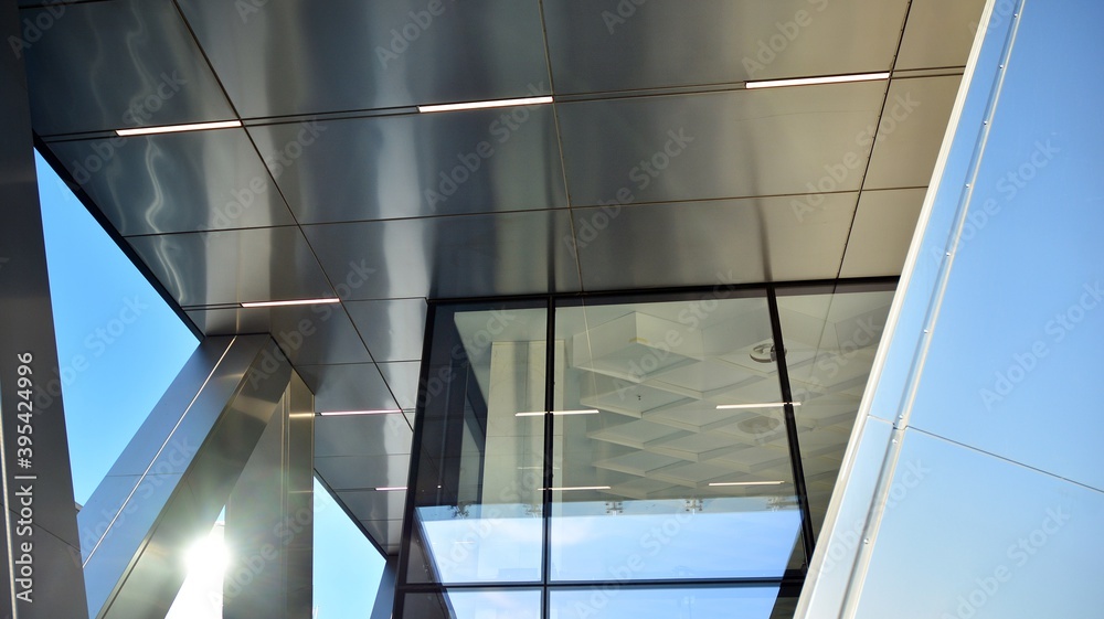 Combination of metal and glass wall material. Steel facade on columns. Abstract modern architecture.