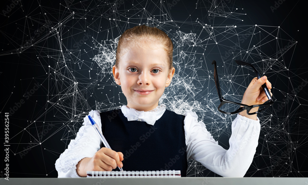 Smiling little girl in schoolwear doing homework