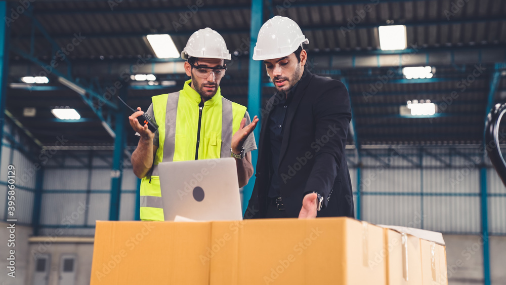 Two factory workers working and discussing manufacturing plan in the factory . Industry and engineer