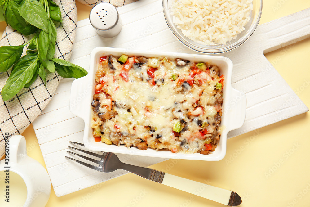 Baking dish with tasty rice casserole on color background