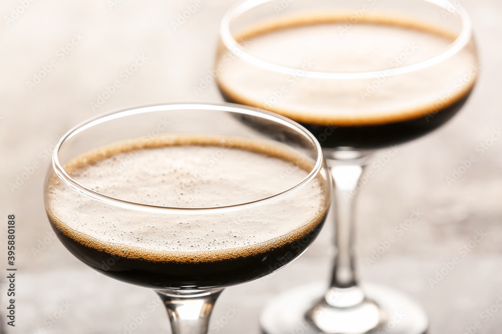 Two glasses of tasty espresso martini cocktail on table