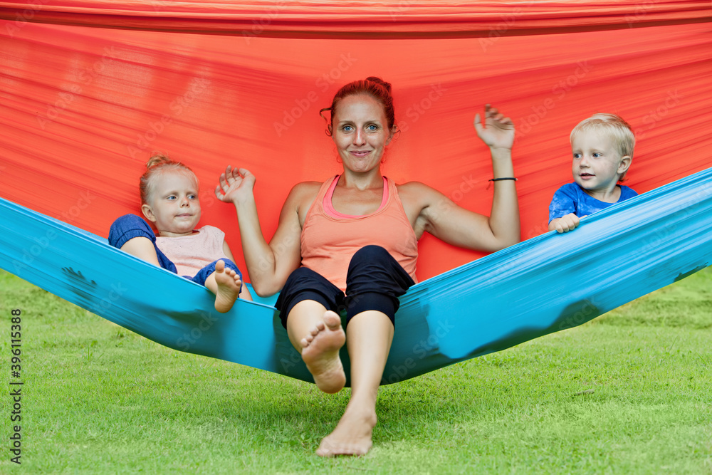 Happy family have fun on tropical beach resort. Funny kids with young mother chilling in swinging ha