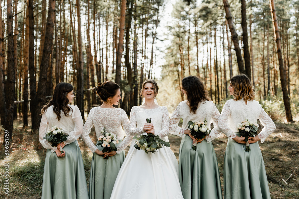 a beautiful bride of European appearance holds a wedding bouquet in her hands and looks at her bride