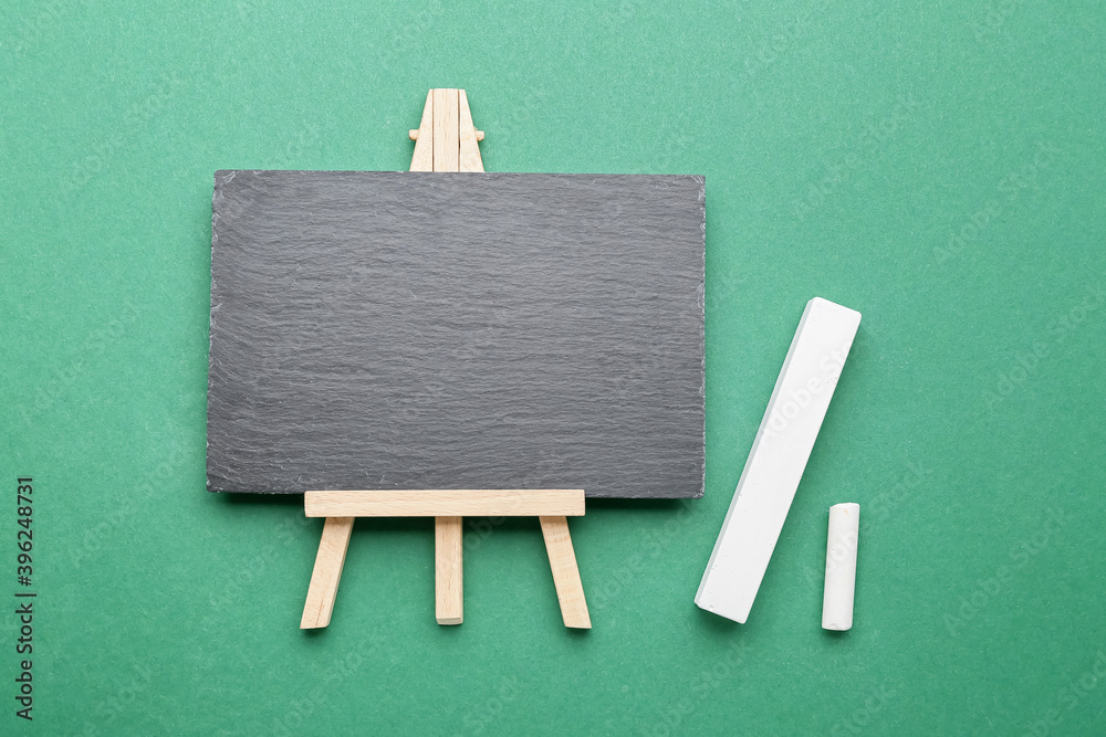 White chalks and chalkboard on color background