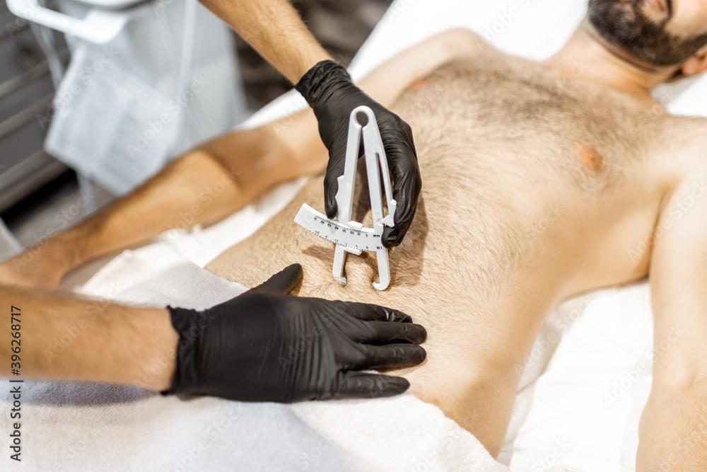 用医用卡尺测定男性腹部皮脂量，特写