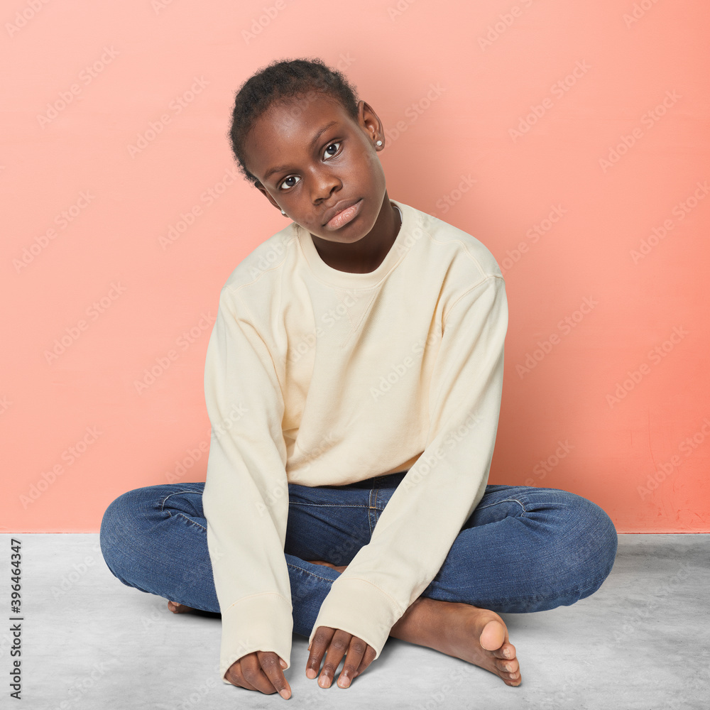 Black kid in a beige sweater