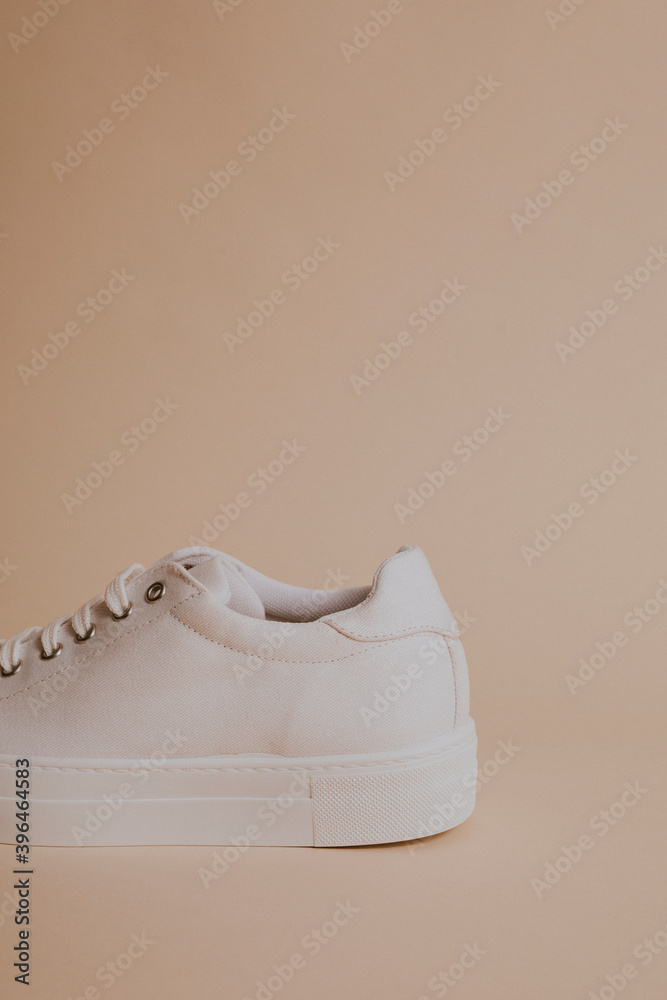 Woman's white canvas sneaker on beige