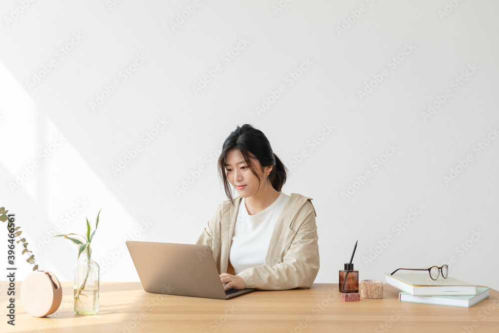 Happy Asian woman at home using a a laptop