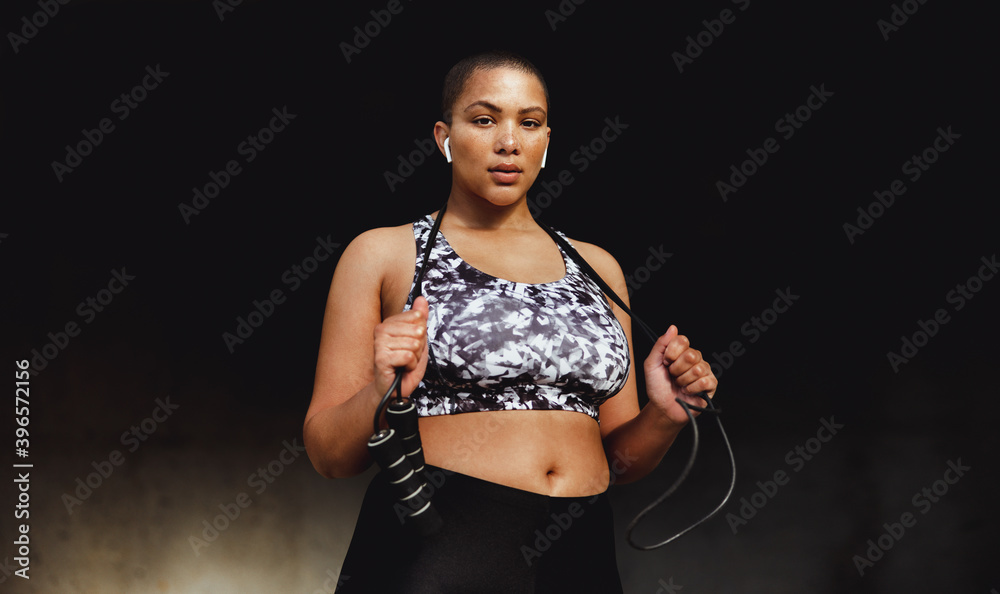 Fitness woman relaxing outdoors holding a skipping rope